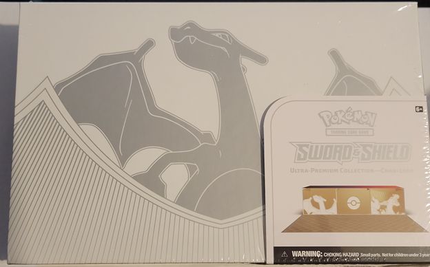 Charizard Ultra Premium Collection comes in a white box with three promotional charizard cards.3 etched foil promo cards: Charizard V, Charizard VMAX, and Charizard VSTAR 1 playmat featuring Gigantamax Charizard 65 card sleeves featuring Gigantamax Charizard 1 metal coin featuring Gigantamax Charizard 6 metal damage-counter dice 2 metal condition markers 1 acrylic VSTAR marker 16 Pokémon TCG booster packs from the Sword & Shield Series