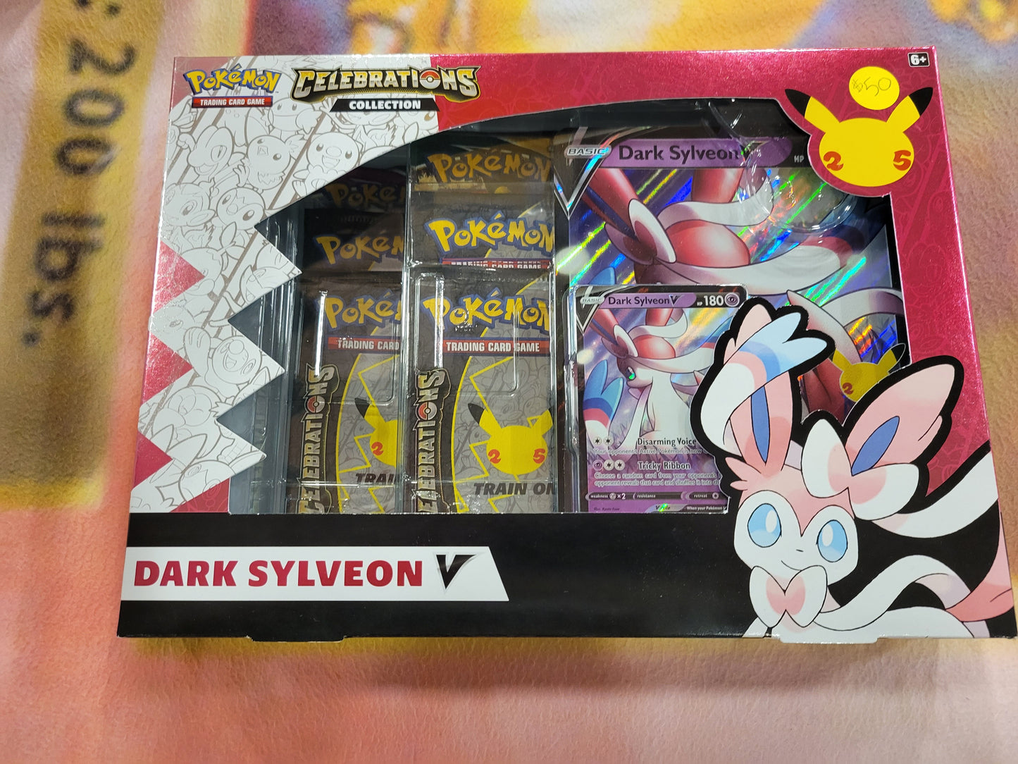Each Dark Sylveon box comes with one oversized Dark Sylveon card, one Celebrations Dark Sylveon card, one online code card, two tcg packs, and four Celebrations packs.